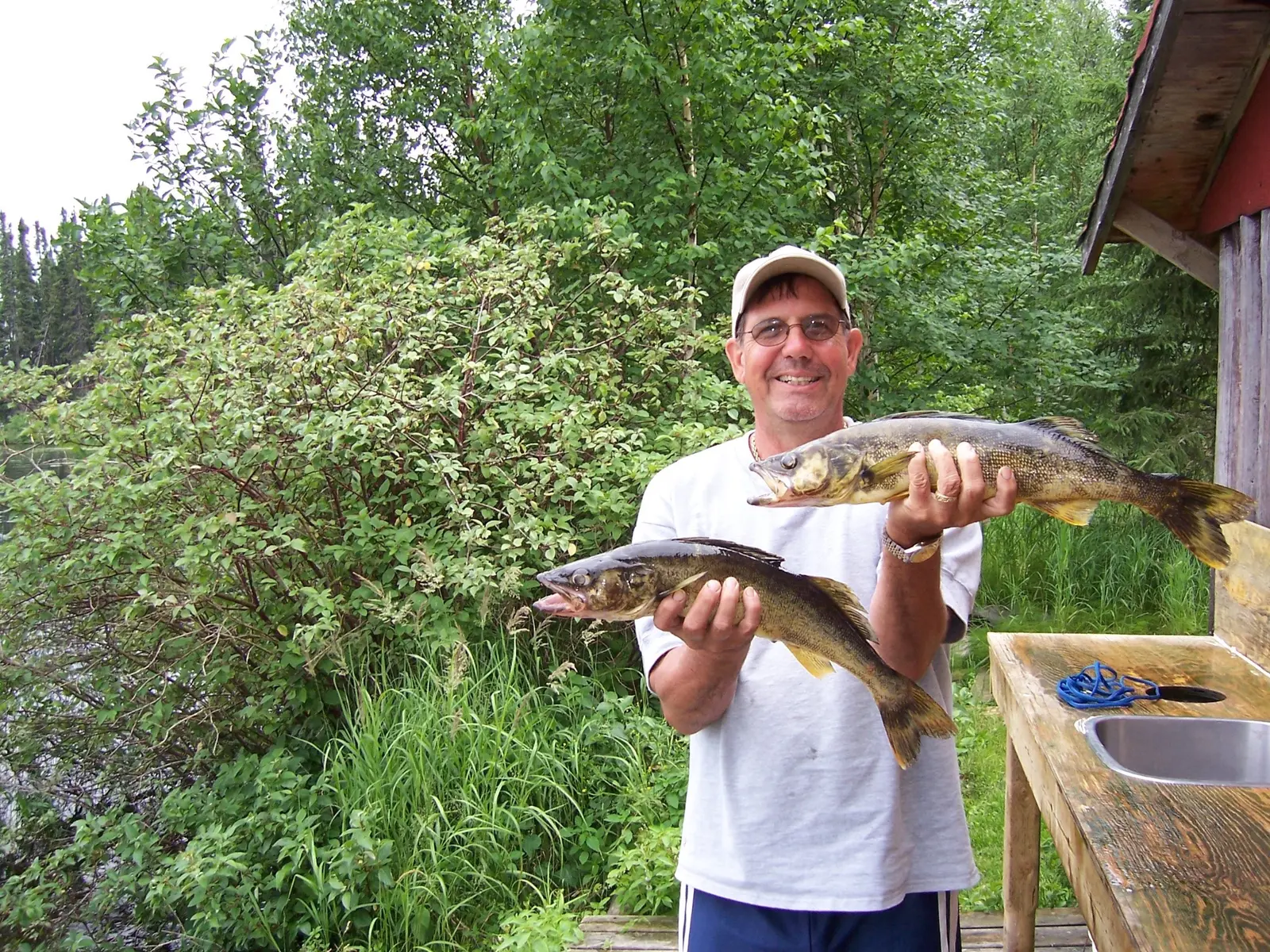 David A. Nowack smiling outdoors while holding two fish