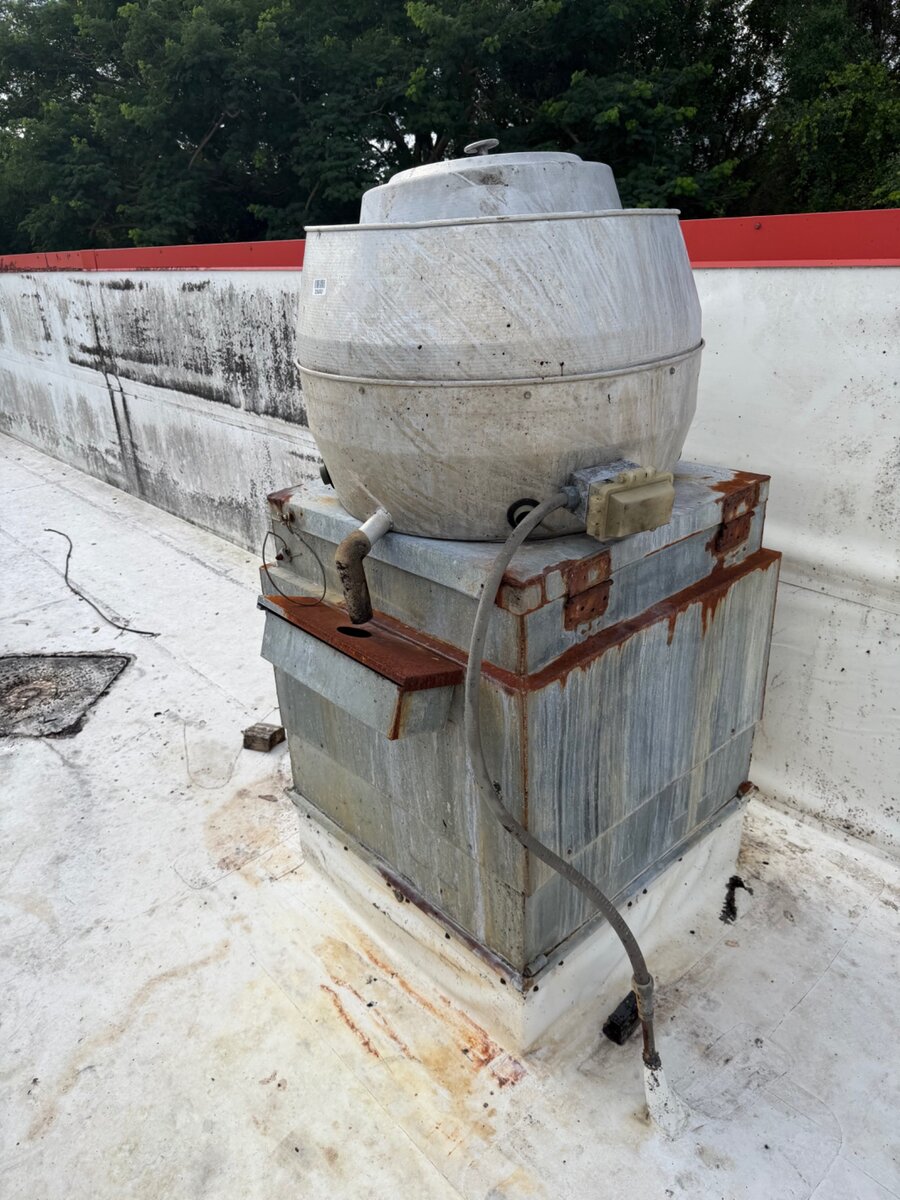 Older commercial rooftop exhaust fan before replacement